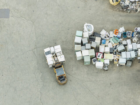 Aerial view of a home appliance recycling plant with a forklift moving refrigerators and televisions on a concrete ground Taiwan.