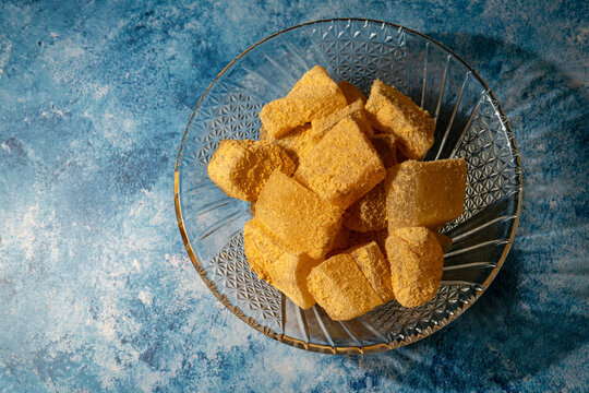 Warabi mochi with kinako powder in glass bowl on blue background