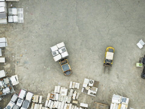 Aerial view of a home appliance recycling plant with forklifts moving refrigerators and air conditioners on a concrete yard Taiwan.