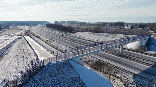 Aerial drone view of S3 expressway with pedestrian overpass in eastern Poland covered in snow. Gorz&oacute;w Wielkopolski