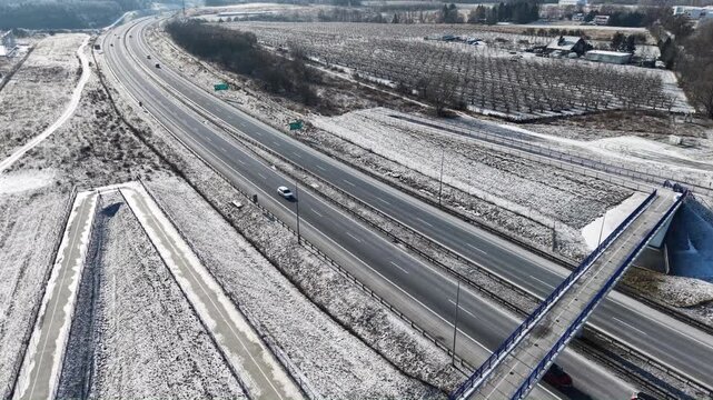 Aerial drone view of S3 expressway with pedestrian overpass in eastern Poland covered in snow. Gorz&oacute;w Wielkopolski