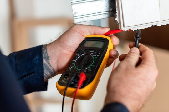 Electrician using digital multimeter tool