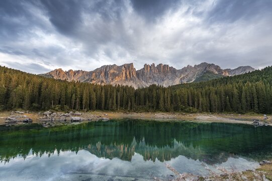 Sunset, dramatic clouds, Latemar group reflected in the Karersee, Diamantidturm, mountain peaks, Eastern Latemarspitze, Col Coron, Lago di Carezza, Welschnofen, Bolzano, South Tyrol, Italy