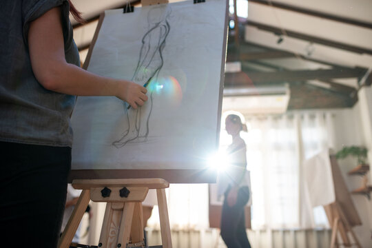 Artistic sketching in sunlit studio.