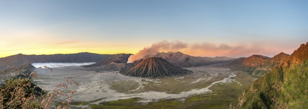 Volcanic landscape at sunrise, panorama, smoking volcano Gunung Bromo, with Mt. Batok, Mt. Kursi, Mt. Gunung Semeru, Bromo-Tengger-Semeru National Park, Java, Indonesia