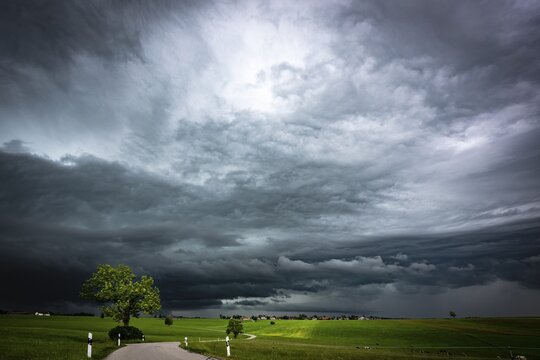Road and meadows with thunderstorm sky in the background, Eggental, Ostallg&auml;u, Swabia, Bavaria, Germany