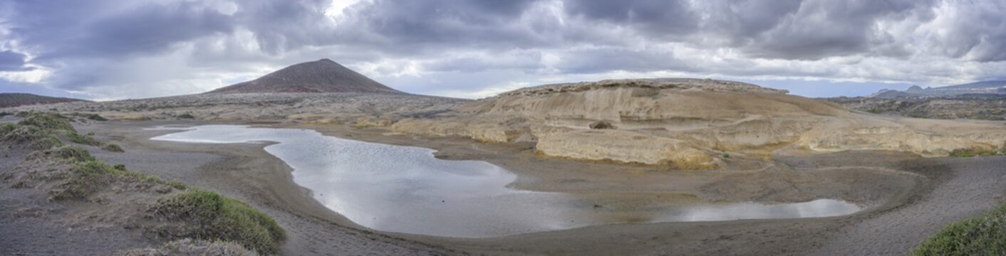 Sandstone structures and behind them the mountain Montana Roja, El Medano, Tenerife, Spain