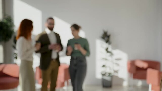 Woman standing alone with a coffee cup, feeling uncomfortable and left out while a group of coworkers communicate in the background. Office social break with colleagues