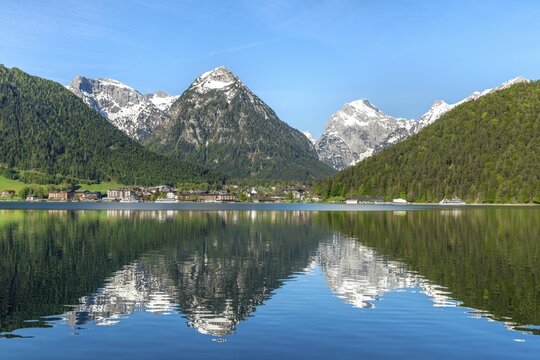 View of Pertisau, reflection in Lake Achensee, in the background mountains Dristenkopf and Falzthurnjoch with snow in spring, Achensee, Tyrol, Austria