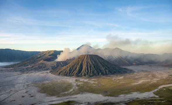 Volcanic landscape at sunrise, smoking volcano Gunung Bromo, with Mt. Batok, Mt. Kursi, Mt. Gunung Semeru, Bromo-Tengger-Semeru National Park, Java, Indonesia