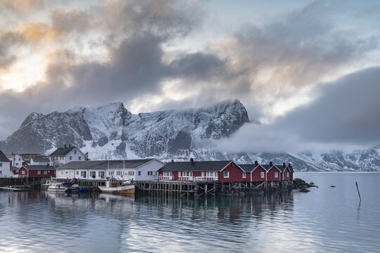 Rorbuer cabins from Hamnoy by the fjord, snowy mountains in the back, Hamn&oslash;y, Moskenes&oslash;ya, Lofoten, Norway