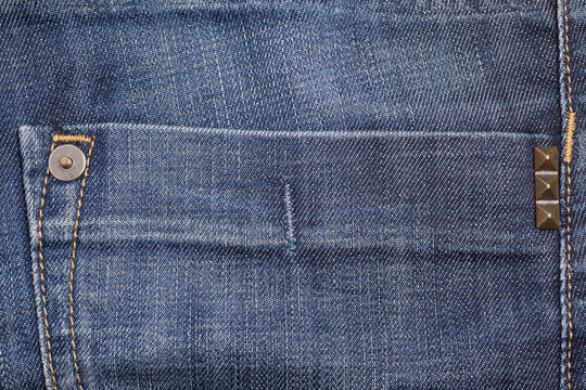 Pyramid metal studs jeans. Denim background.