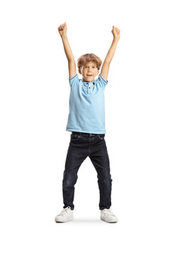 Joyful young boy celebrating with arms raised in the air