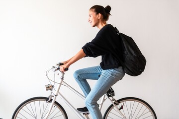 Naklejka premium Young woman riding bicycle indoors