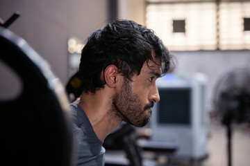 Profile portrait of intense athletic man in gym after hard workout. Serious face covered in sweat shows extreme focus for fitness exercise with determined expression during heavy training © 220 Selfmade studio