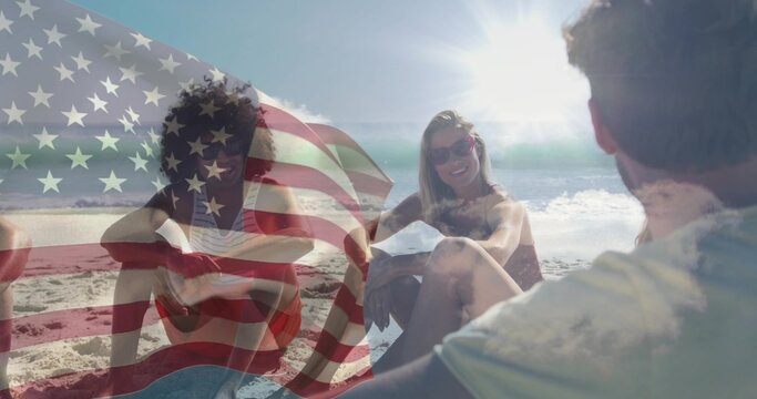 Sitting five friends chatting on beach, wearing swimwear and sunglasses with American flag overlay