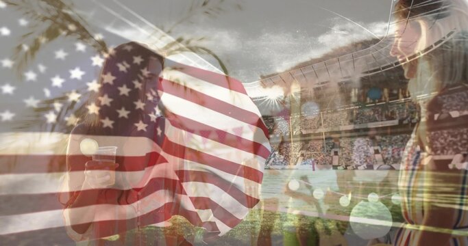 Talking eight adults in casual clothes with plastic cup, watching game at arena, US flag overlay