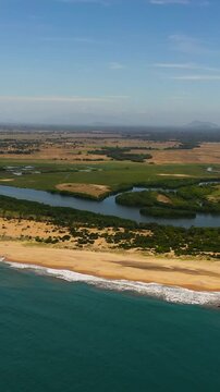 View from the sea to the coastline of Sri Lanka with the beach, river and agricultural land. Whiskey point, Sri Lanka. Vertical video.