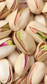 Pile of roasted pistachios in shells rotating slowly. Top view