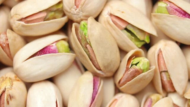 Pile of roasted pistachios in shells rotating slowly. Top view