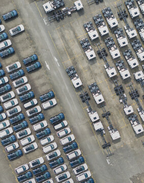 Aerial view of rows of new vehicles and truck chassis at a car dealer logistics lot in Taiwan.
