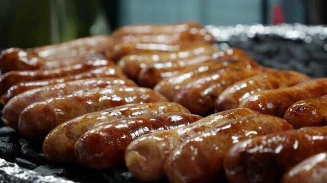 Several browned sausages resting on hot stones at a market cooking station forming a compact snack display for outdoor vendor preparation. Ready to eat food.