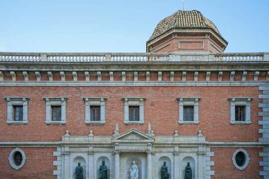 Ciutat Vella,Valencia,Spain,Facade of a historic red brick building with classical architectural details and statues