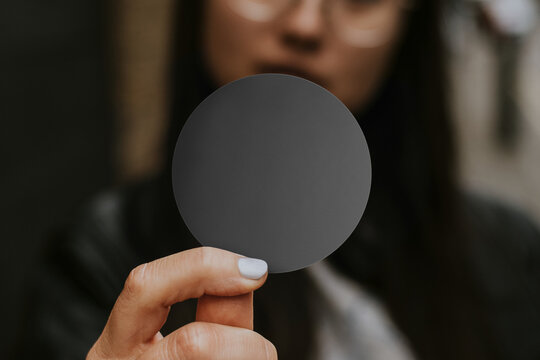 Person holding blank round card, suitable as mockup