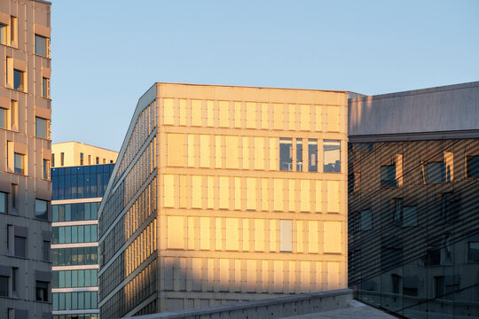 Modern urban corporate offices and buildings facade with windows in warm sunlight showing architecture pattern and dramatic shadows for contemporary city background