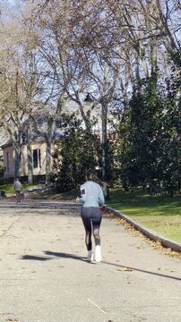 Mujer runner corredora en footing y jogging entrenando aer&oacute;bico con brazalete y funda de m&oacute;vil en brazo en naturaleza por parque
