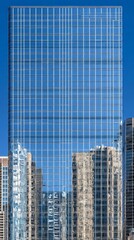 Obraz premium Modern skyscraper with reflective glass facade in urban cityscape