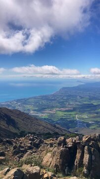 Sweeping mountain panorama revealing the sparkling Mediterranean Sea, Estepona and distant Gibraltar beneath open skies from Sierra Bermeja in Spain.
