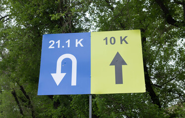 Obraz premium Road race distance direction signs 21.1K half marathon and 10K route arrow markers at running event