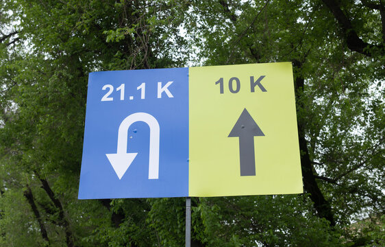 Road race distance direction signs 21.1K half marathon and 10K route arrow markers at running event