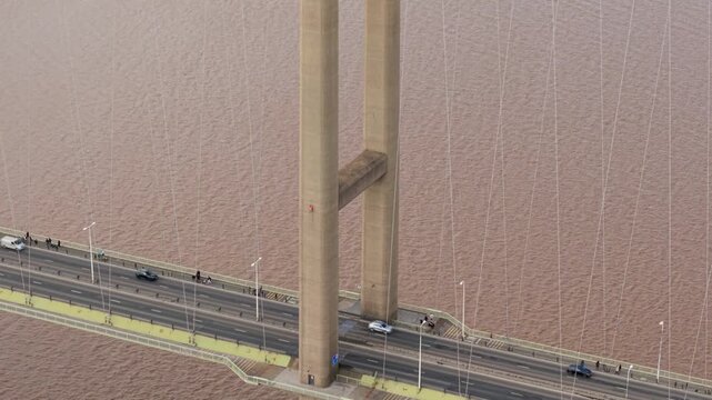 Close up aerial view of the Humber Bridge suspension cables and towers with busy road traffic UK