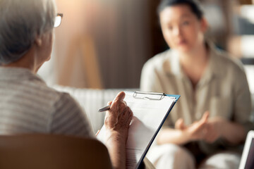 Professional Therapy Session with Counselor Taking Notes and Patient Communicating