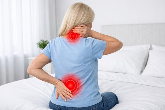 Back and neck pain discomfort in woman sitting on bed. Ai generative