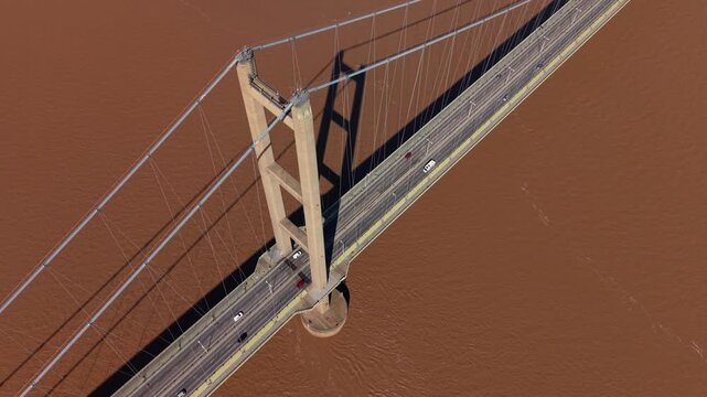 Cinematic close up of the Humber Bridge road deck and suspension system over brown river water