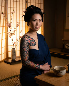 Woman with large traditional Japanese tattoo sitting in a room
