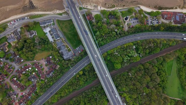 Top down aerial view of Hessle Foreshore and the Humber Bridge tower over the muddy estuary shoreline UK