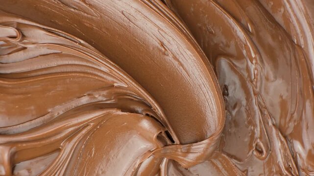 Macro texture of smooth brown chocolate nut spread swirl