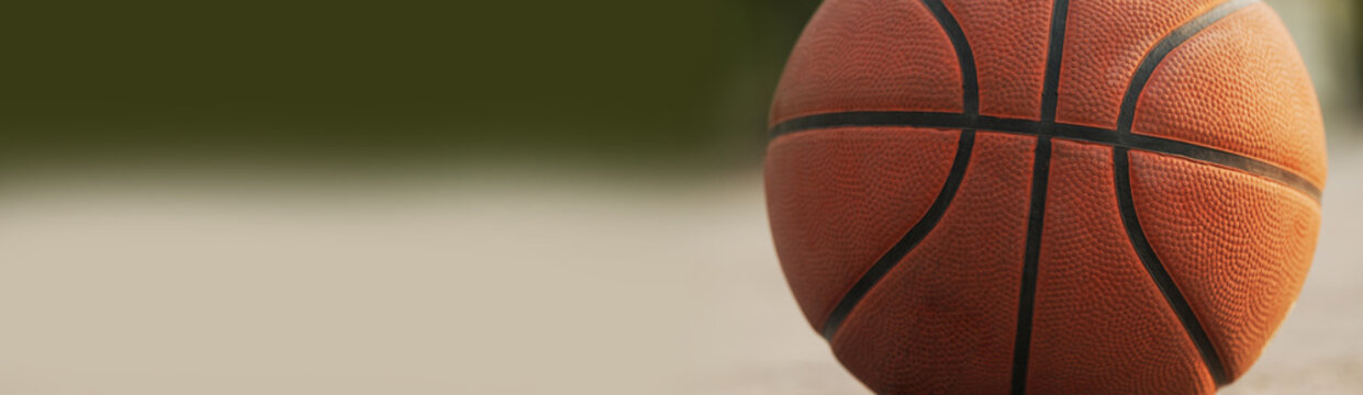 Close-up of a basketball on an outdoor court with soft bokeh background