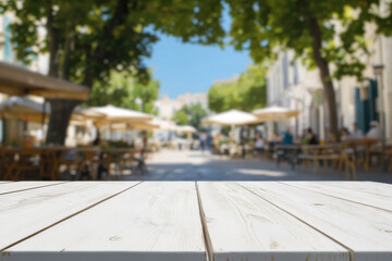 Fototapeta premium Empty white wooden table overlooking a blurred outdoor cafe