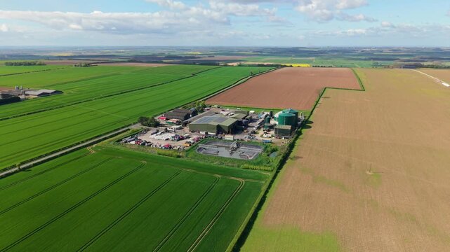 Drone shot of a rural renewable energy plant generating biogas from agricultural waste in the English countryside