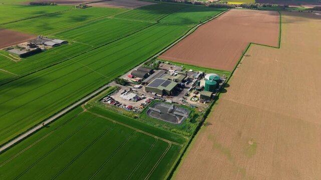 Aerial view of an anaerobic digester facility and biogas domes surrounded by colorful fields in Lincolnshire UK
