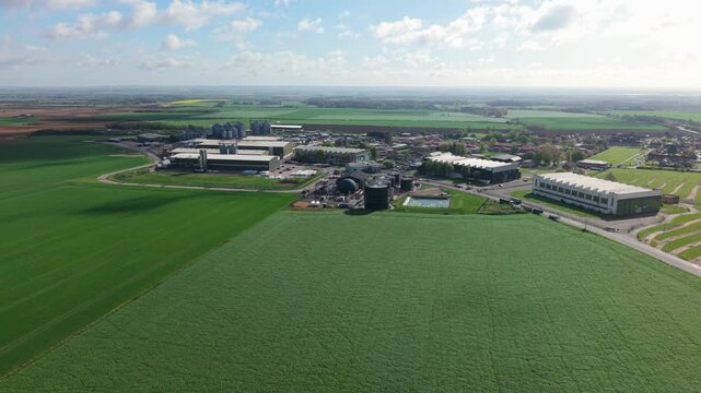 Birds eye view of geometric industrial farm warehouses and grain silos nestled in flat Lincolnshire arable land