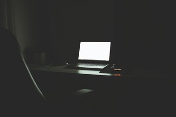 Dark workspace with laptop glow in moody light