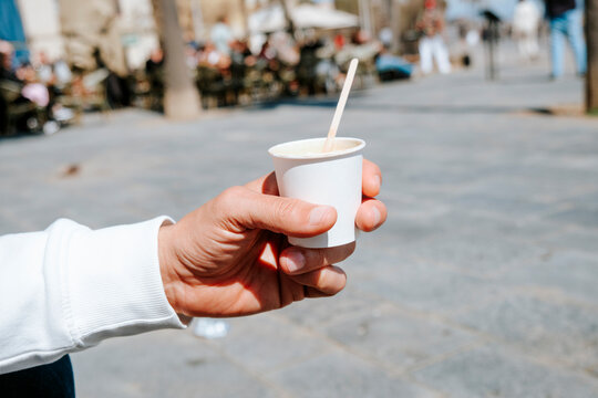 man with an espresso macchiato in a takeaway cup