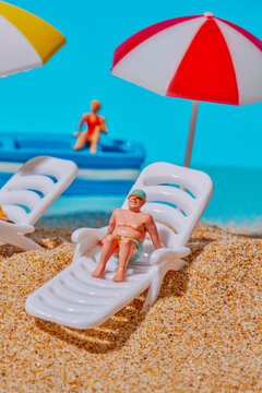a miniature man resting on a sun lounger