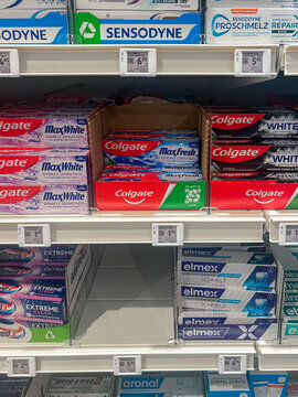 Karlsruhe, Germany- May 13, 2025: Multiple brands of toothpaste packaging boxes stocked in market store in Germany. Dental hygiene, lifestyle, cost of living, retail sales concepts